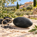 Black 155g activated charcoal pebble soap on a rope with charcoal pieces in Provence