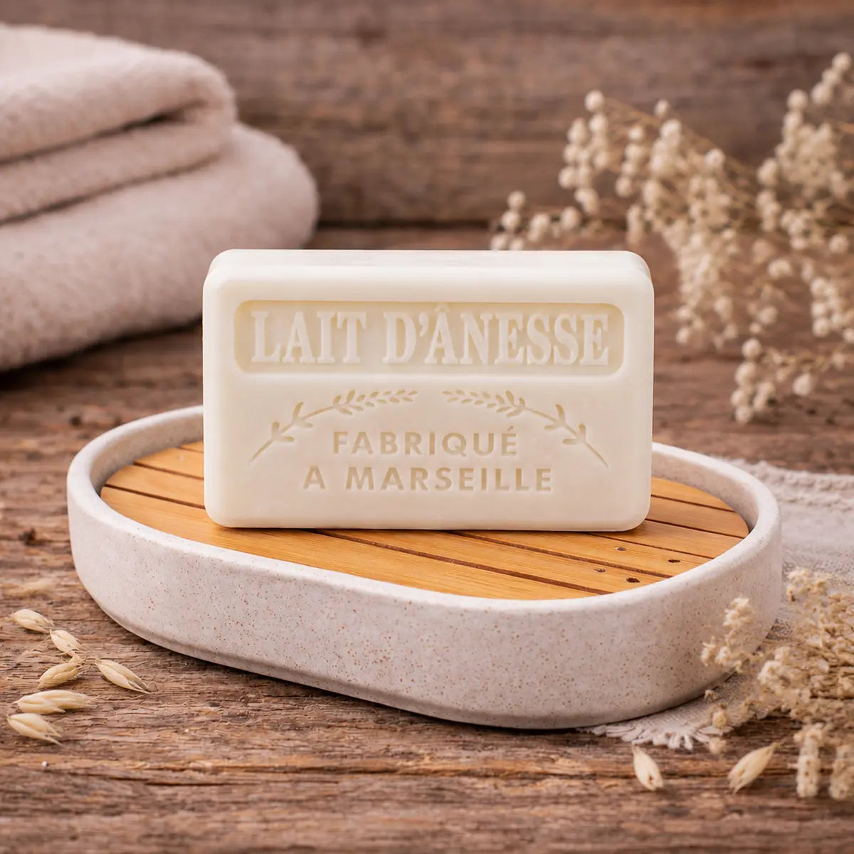 Ivory 60g Lait d’Ânesse donkey milk guest soap, made in Marseille, displayed on a ceramic soap dish.