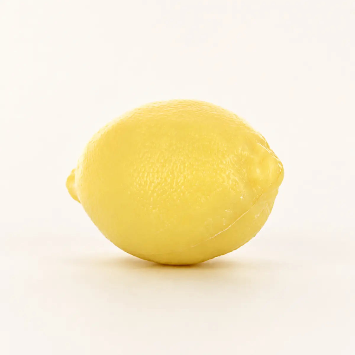 Yellow lemon-shaped 125g French soap with realistic citrus texture