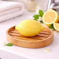 Yellow lemon-shaped 125g French soap with realistic citrus texture in a bathroom