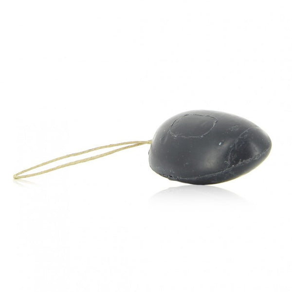 A small black oval-shaped soap with a thin beige string attached, photographed on a clean white background.