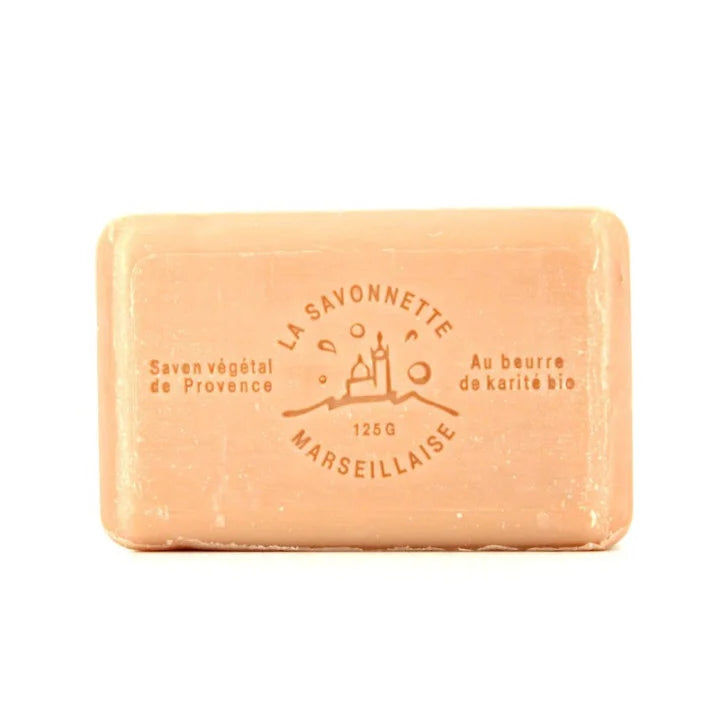 A rectangular peach-colored bar of soap with embossed text