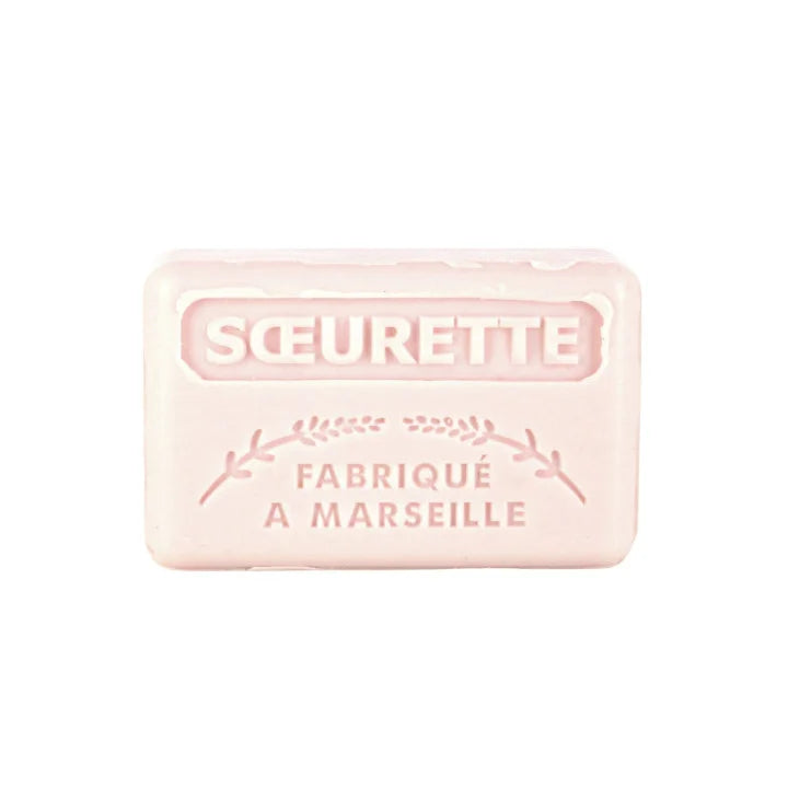 A pale pink rectangular bar of soap embossed with the brand name 'SOEURETTE' and 'FABRIQUÉ A MARSEILLE' on a plain white background.